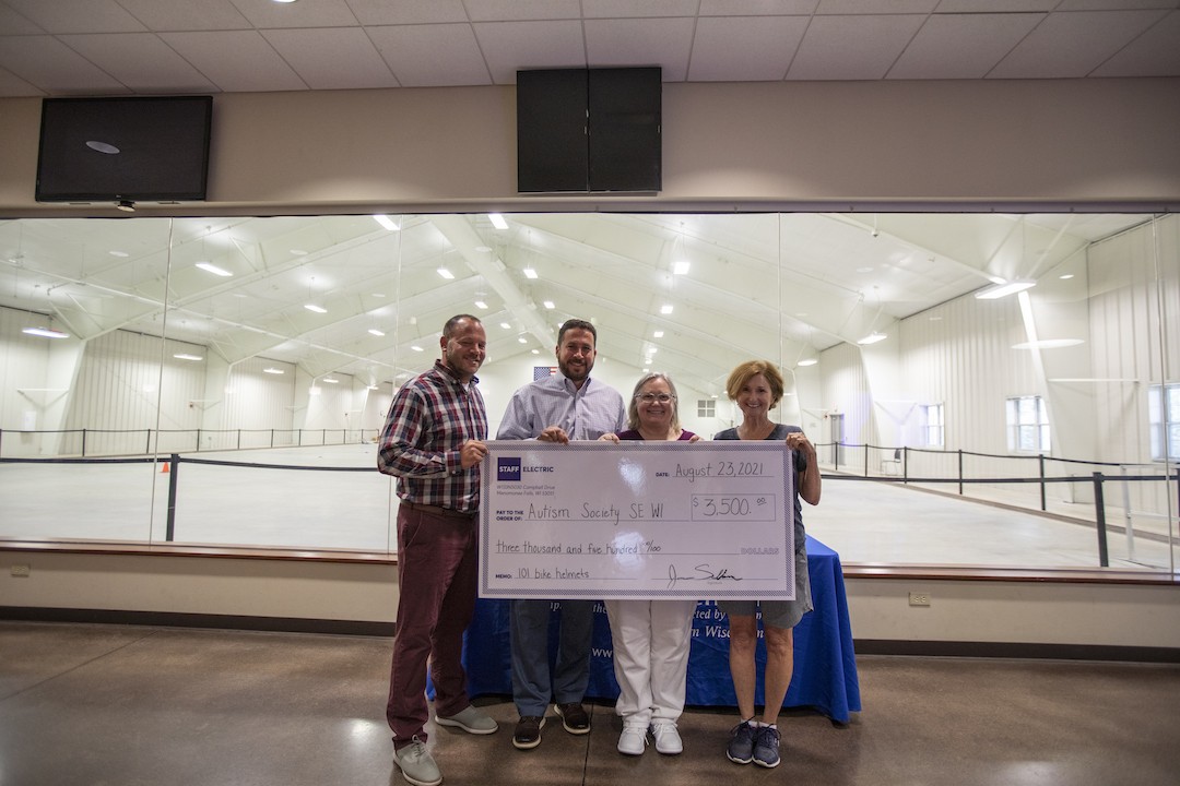 Staff electric employees holding a check at the ican bike event.